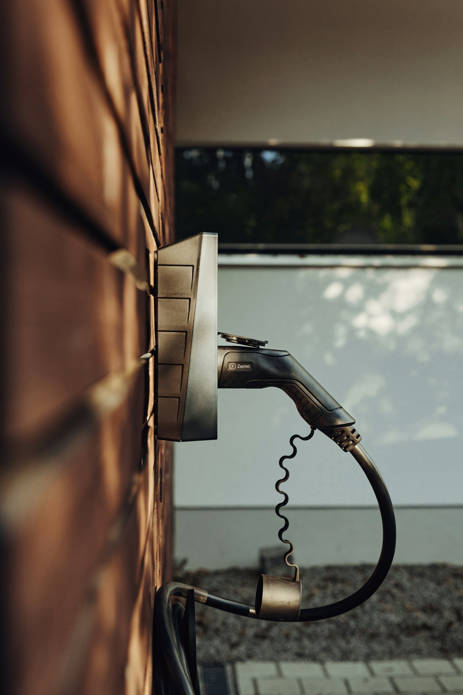 Wall-mounted Level 2 EV charger installed on a brick exterior